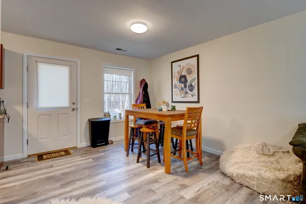 a dining room with furniture and wooden floor