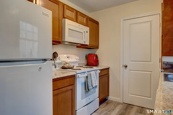 a kitchen with stainless steel appliances granite countertop white cabinets sink and a refrigerator