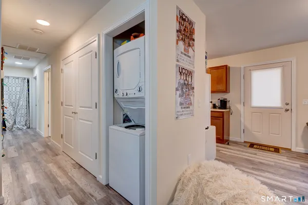 a view of a hallway with wooden floor and closet