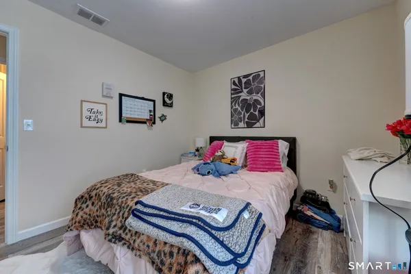 a bedroom with a bed and wooden floor