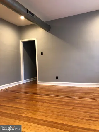 a view of a room with wooden floor and a window