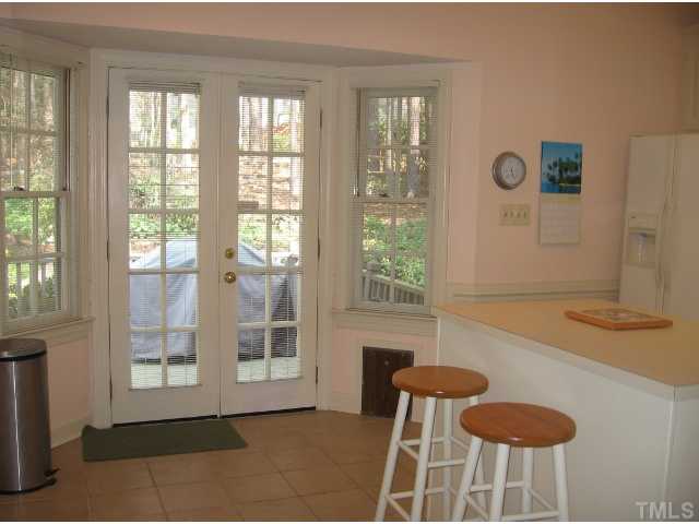Bright sunny kitchen with french doors to the deck, pet door, kitchen island and tile floors