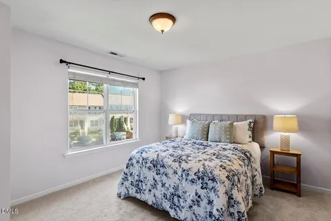 a bedroom with a bed and a lamp next to a window