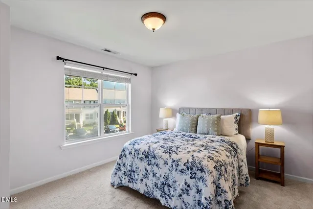 a bedroom with a bed and a lamp next to a window