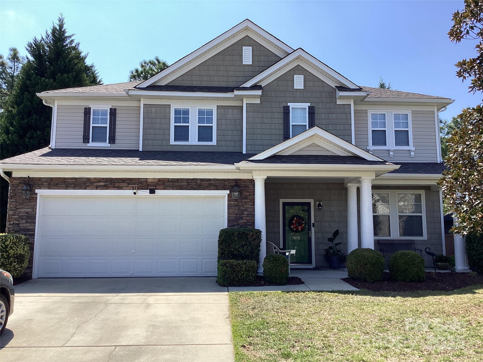 a front view of a house with a yard and garage