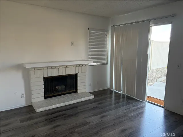 a view of a livingroom with a fireplace and wooden floor