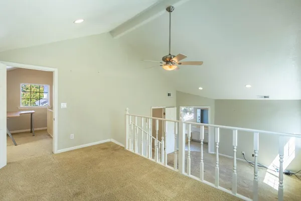 an empty room with a chandelier fan and closet