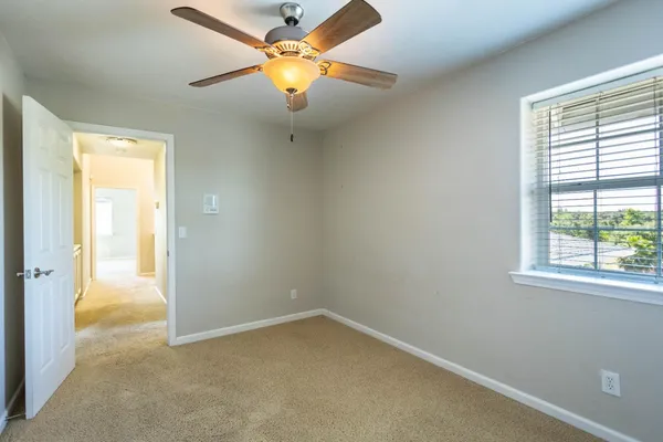 a kitchen with granite countertop a refrigerator oven a sink dishwasher and white cabinets with wooden floor