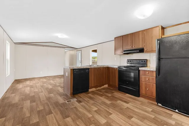 a kitchen with a refrigerator and a stove top oven