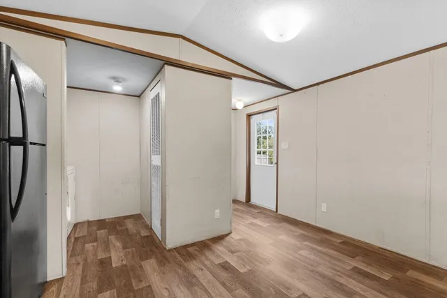 a view of hallway with wooden floor and a cabinet