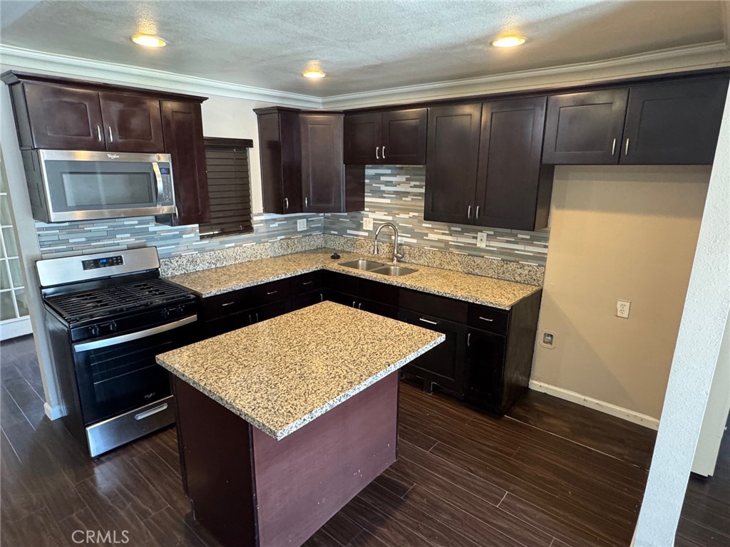 926 Griffith Way Hemet, CA 92543 - Photo 4 of 30 a kitchen with kitchen island granite countertop wooden cabinets and a counter top