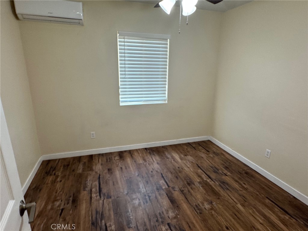 926 Griffith Way Hemet, CA 92543 - Photo 7 of 30 a view of an empty room with wooden floor and a window