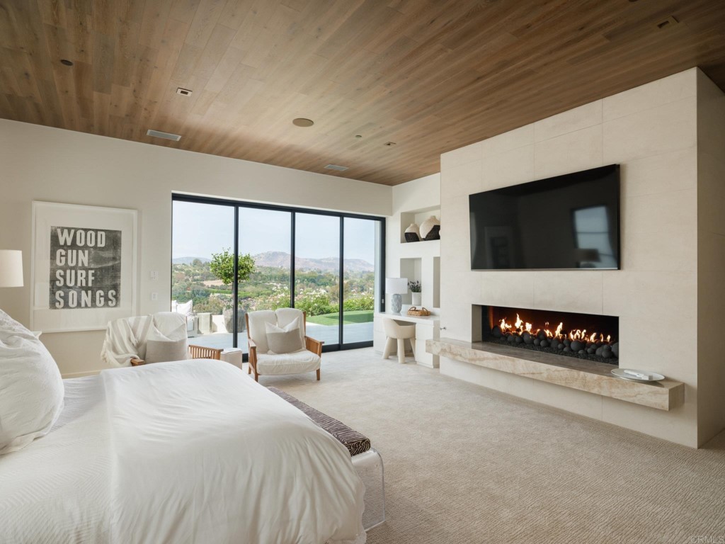 5516 La Crescenta Road Rancho Santa Fe, CA 92067 - Photo 38 of 68 a bedroom with a bed a flat screen tv and a large window with the outer view