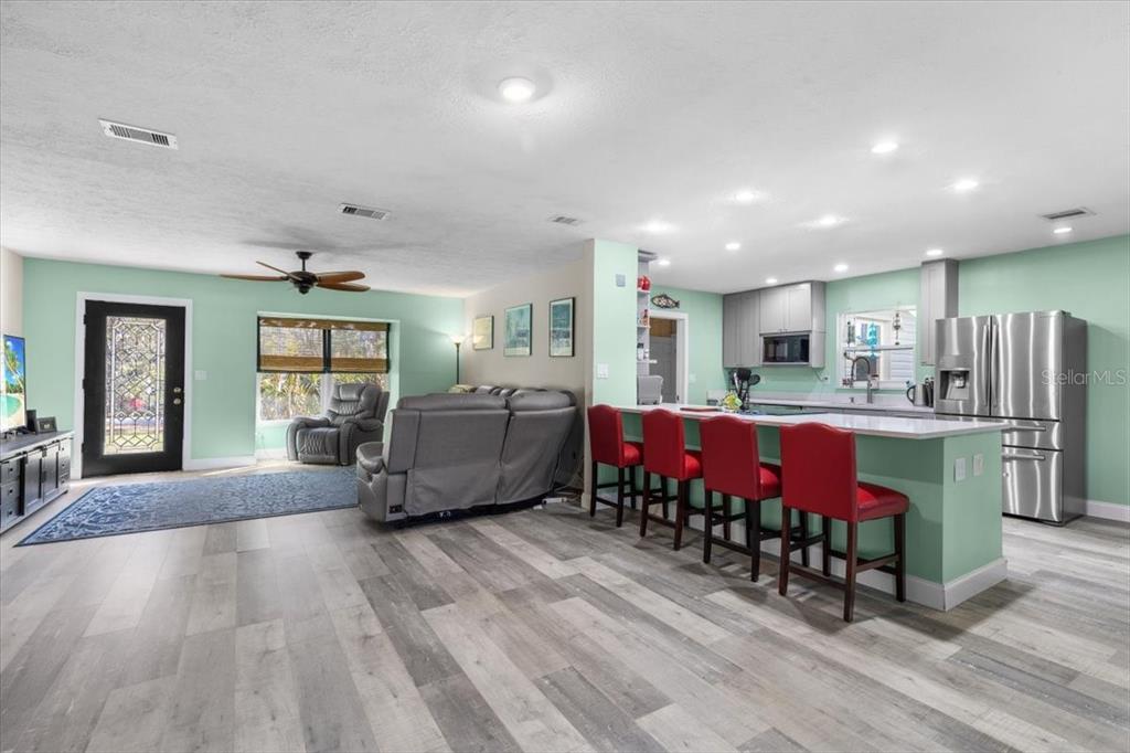 7226 Alafia Ridge Loop Riverview, FL 33569 - Photo 12 of 51 a large room with stainless steel appliances lots of wooden furniture a fireplace and windows