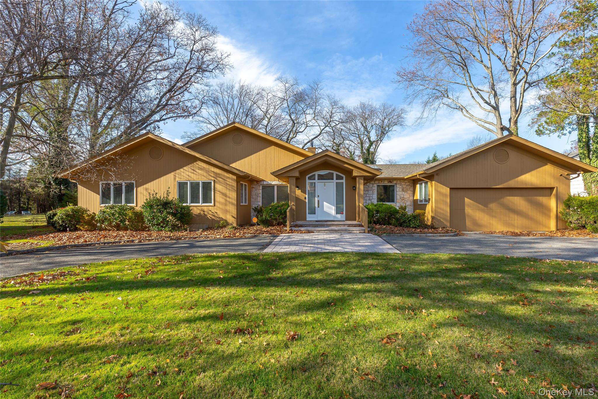 79 Meadow Woods Road Great Neck, NY 11020 - Photo 1 of 1 a front view of a house with a yard table and chairs