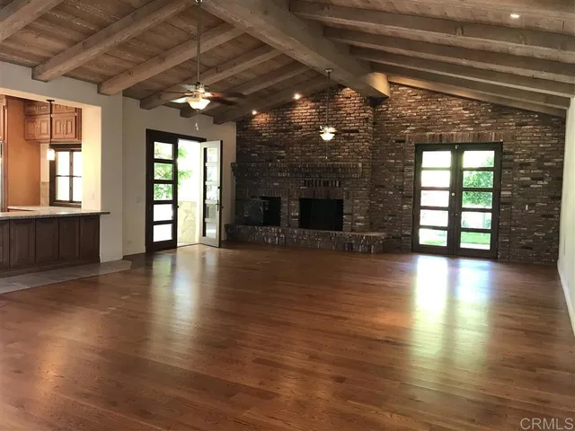 an empty room with wooden floor and a fireplace