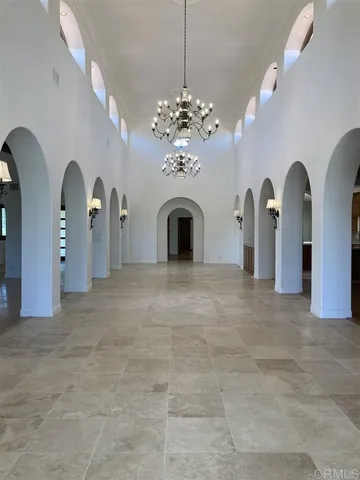 a view of a big room with chandelier fan and kitchen view