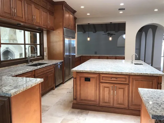 a kitchen with stainless steel appliances granite countertop wooden cabinets and a sink
