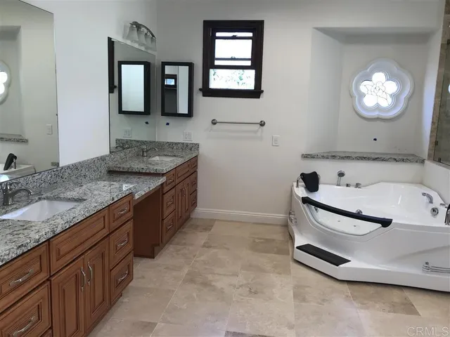 a bathroom with a granite countertop sink and mirror
