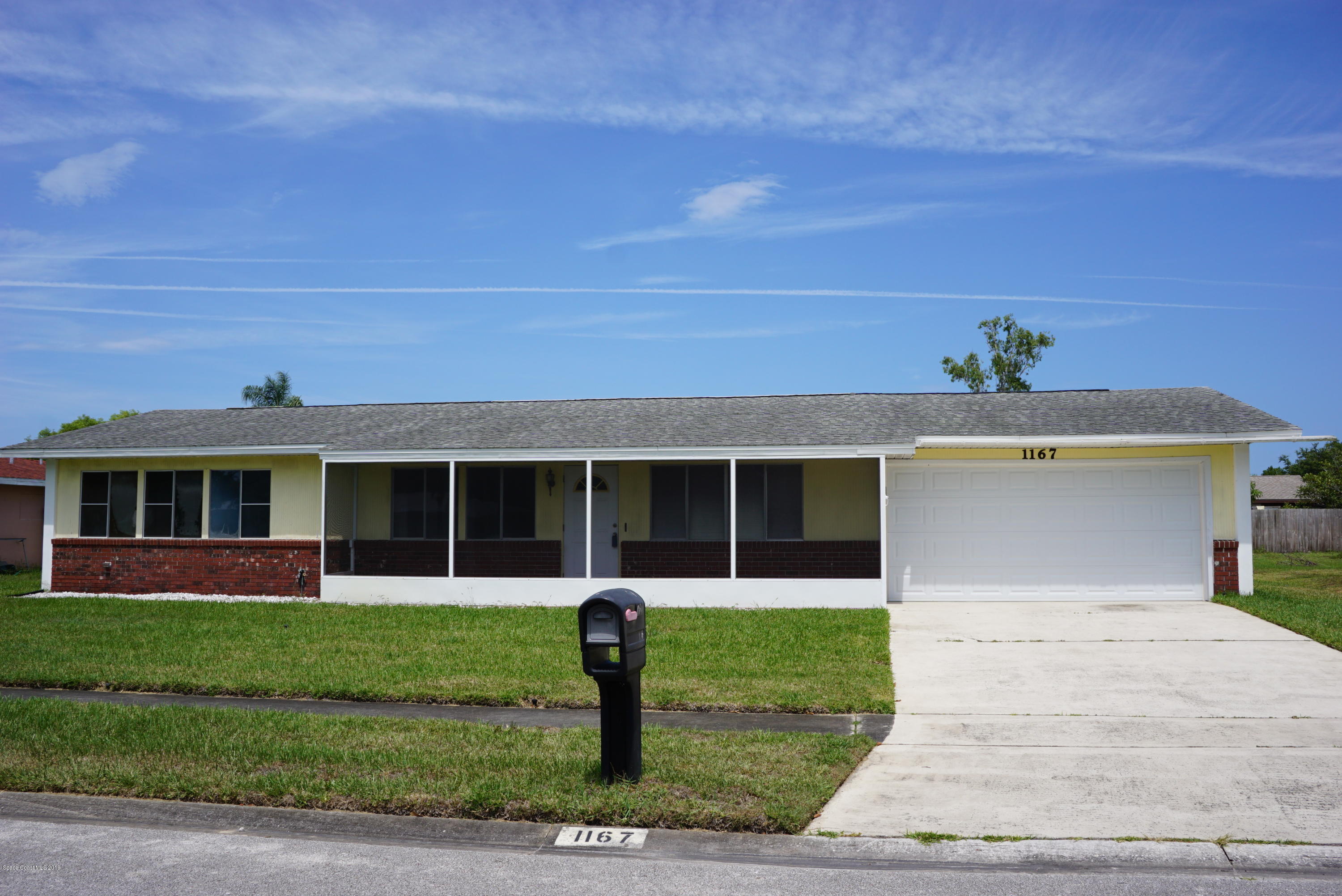 1167 Cotton Road Northeast Palm Bay, FL 32905 - Photo 1 of 34 a front view of a house with a yard and potted plants