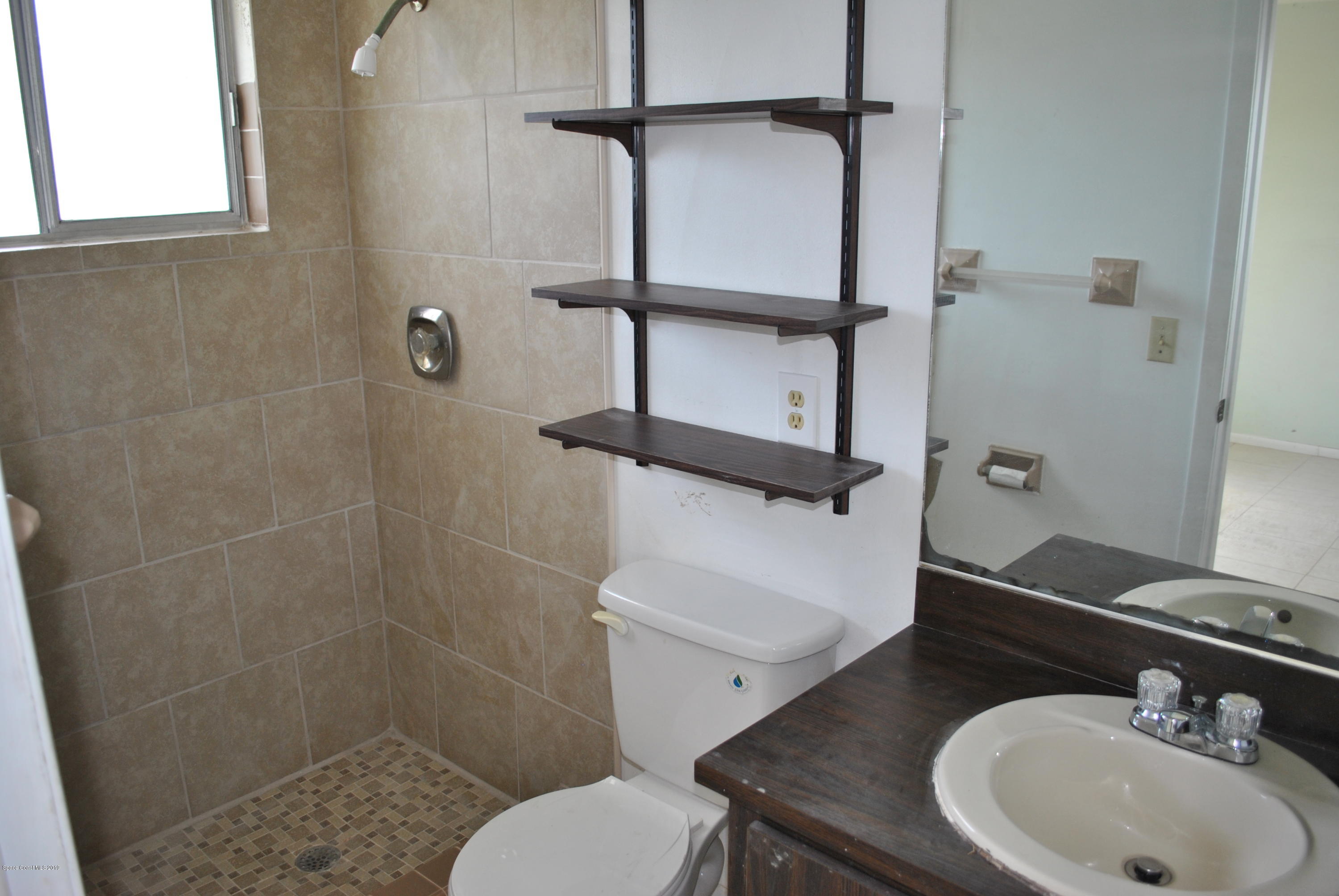 1167 Cotton Road Northeast Palm Bay, FL 32905 - Photo 20 of 34 a bathroom with a sink a toilet and shower