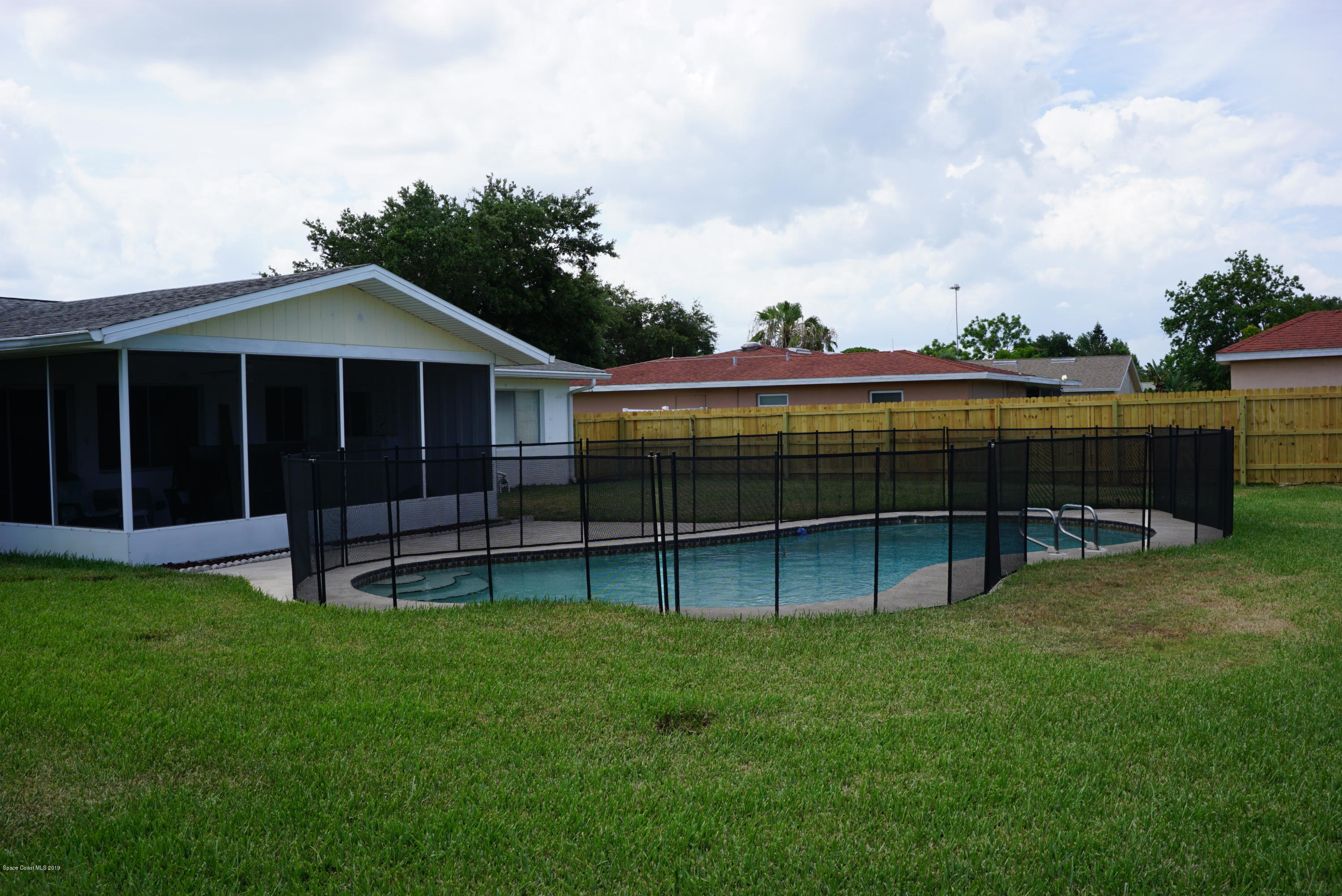 1167 Cotton Road Northeast Palm Bay, FL 32905 - Photo 30 of 34 a view of a yard with wooden fence and a large tree