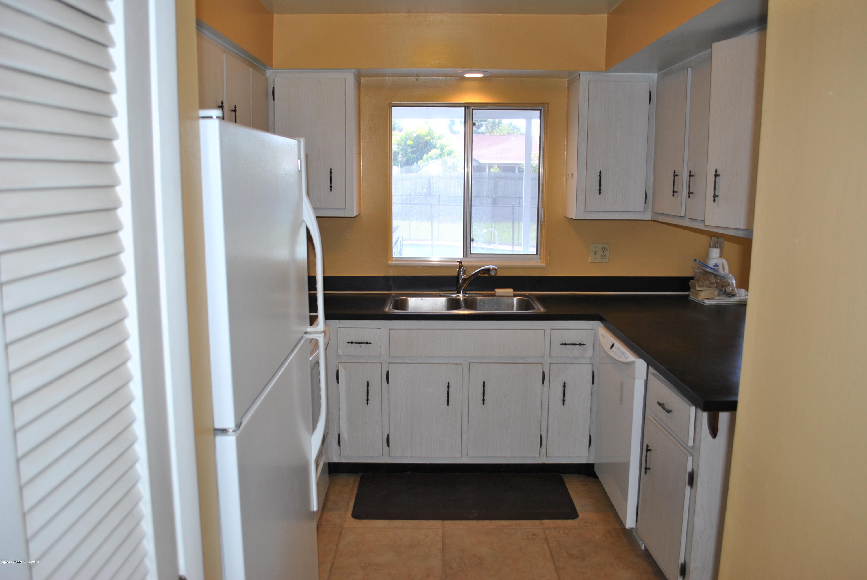 1167 Cotton Road Northeast Palm Bay, FL 32905 - Photo 5 of 34 a kitchen with a refrigerator and window
