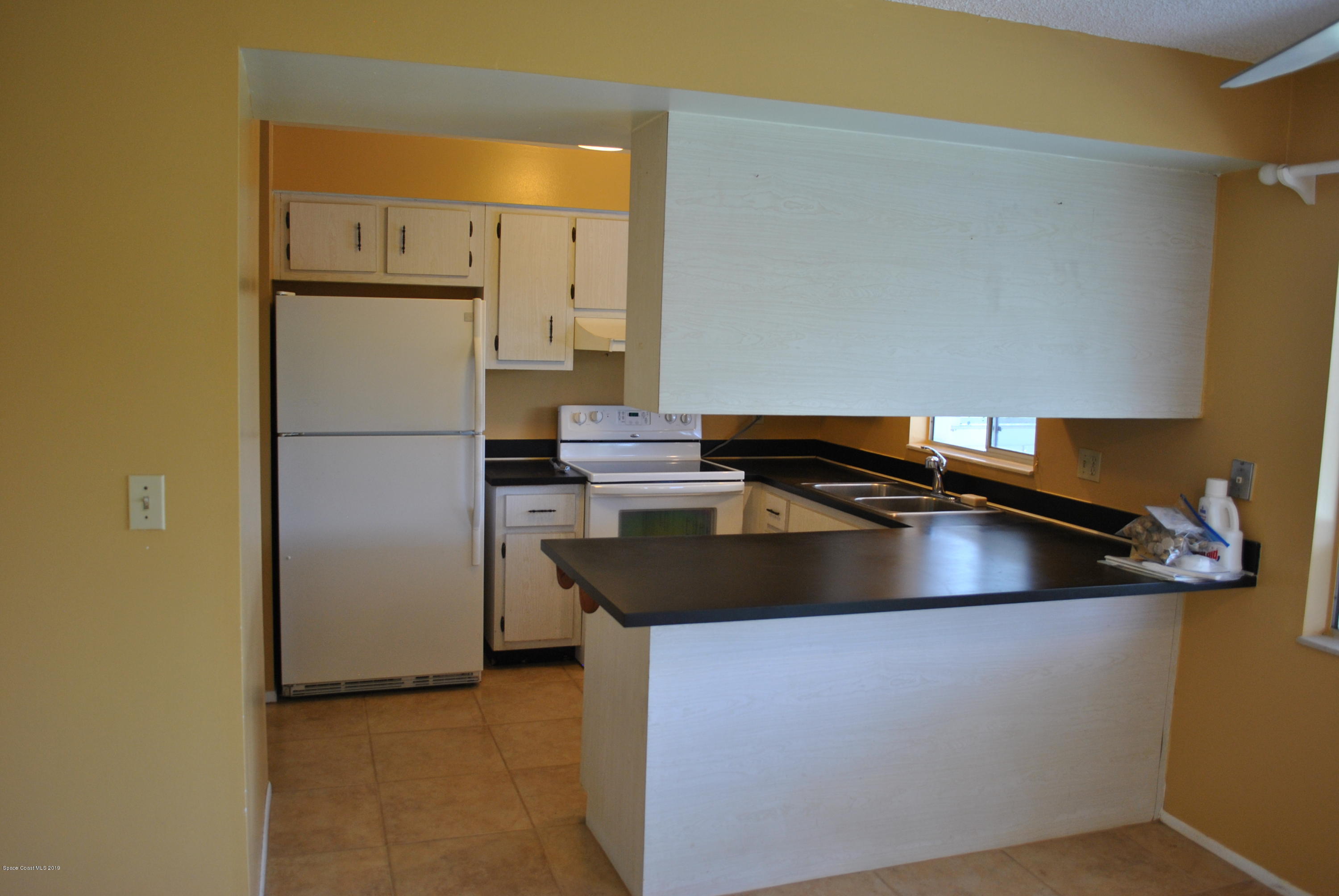 1167 Cotton Road Northeast Palm Bay, FL 32905 - Photo 6 of 34 a view of a kitchen with a sink and a refrigerator