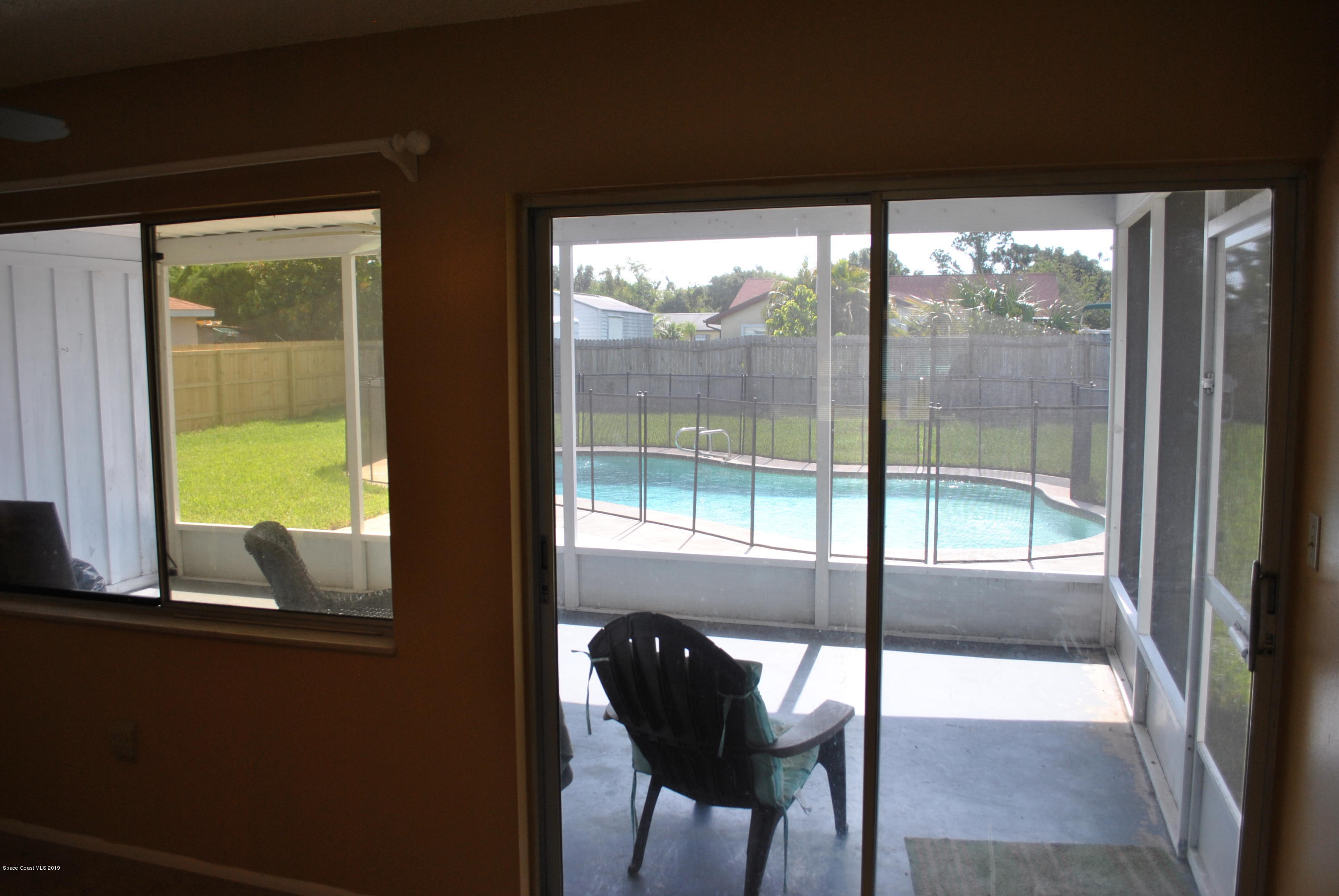 1167 Cotton Road Northeast Palm Bay, FL 32905 - Photo 7 of 34 a view of a room and chair and floor to ceiling window