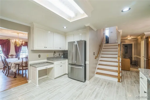 a kitchen with a refrigerator a stove top oven and cabinets