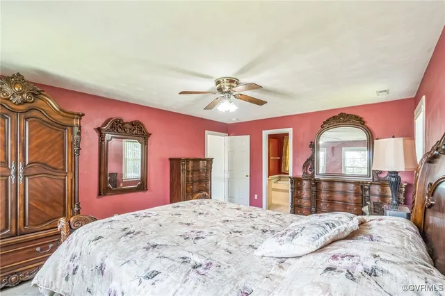 a bedroom with a bed dresser and a large mirror on the dresser