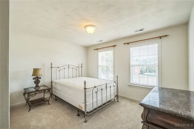 a bedroom with a bed chair and window