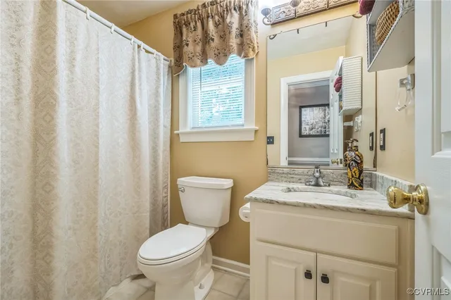 a bathroom with a granite countertop sink toilet and mirror