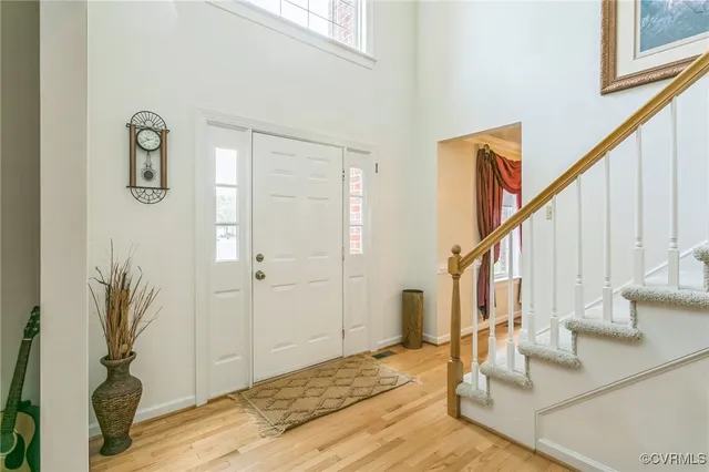 a view of front door with hallway and wooden floor