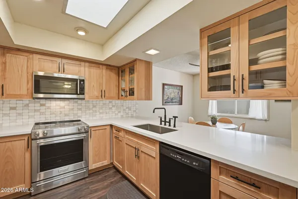 a kitchen with white cabinets and wooden floor