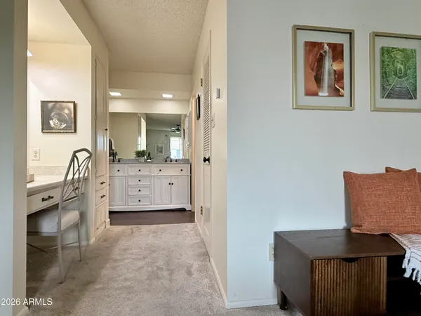 a bedroom with a bed and a large mirror on the dresser