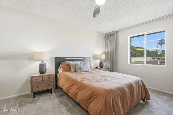 a bedroom with a bed next to a window