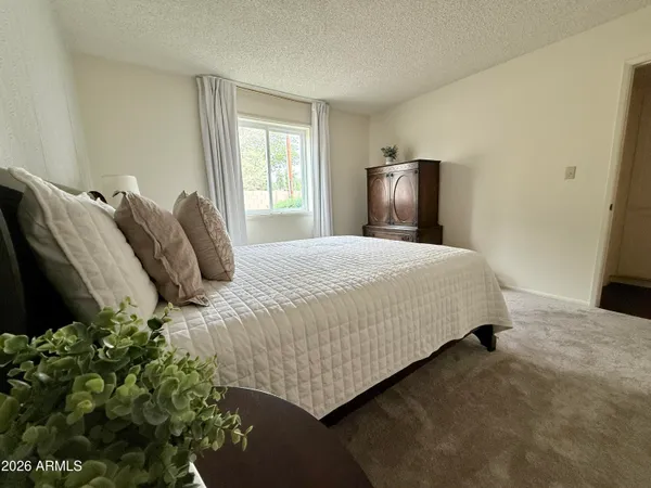 a bed sitting in a bedroom next to a window