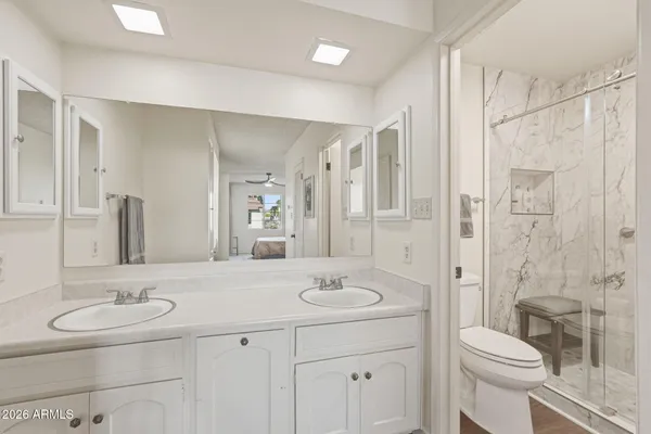 a bathroom with a sink toilet a mirror and shower