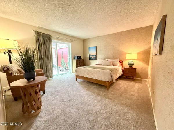 a living room with furniture a rug and a floor to ceiling window