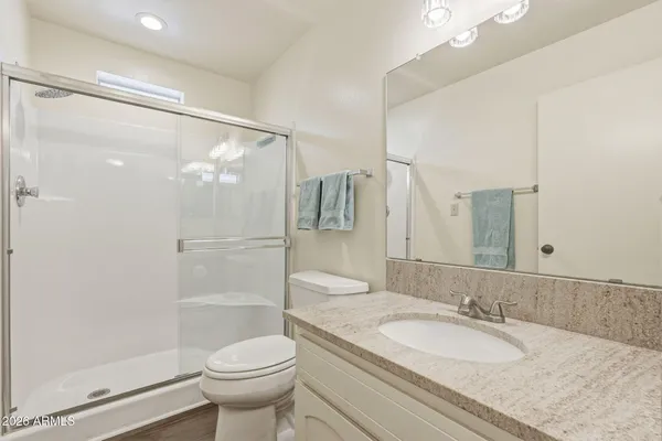 a bathroom with a granite countertop sink toilet and shower