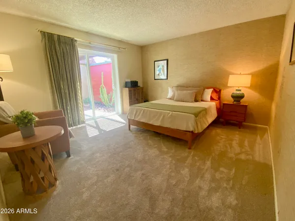 a spacious bedroom with a bed and a potted plant