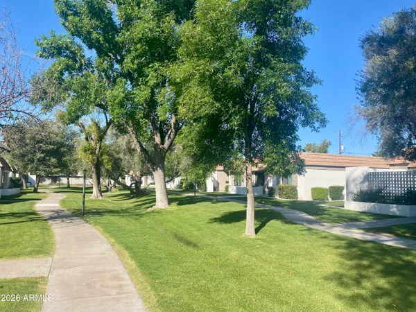 a backyard of a house with lots of green space and fountain