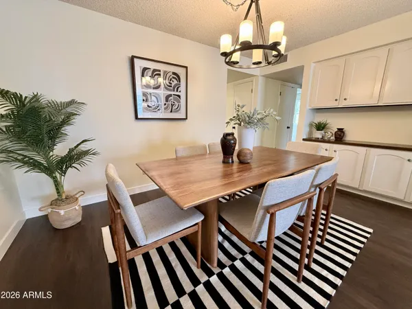 a view of a dining room with furniture a chandelier and wooden floor