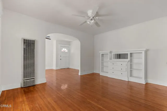 an empty room with wooden floor and cabinet