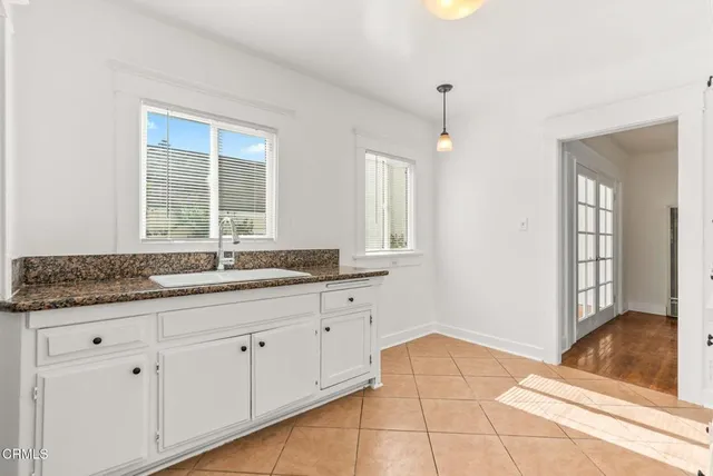 a bathroom with a granite countertop sink and a window