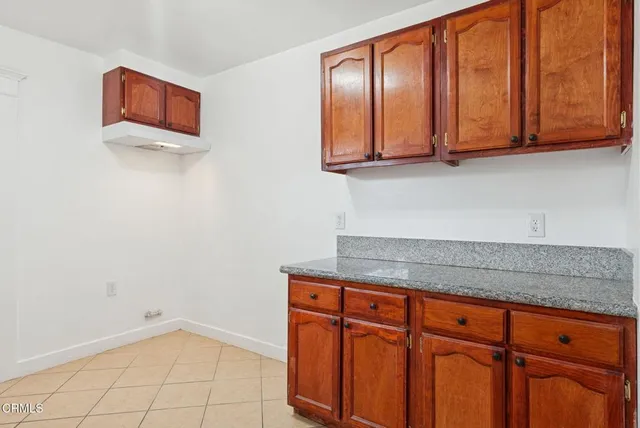 an empty room with wooden floor ceiling fan and windows
