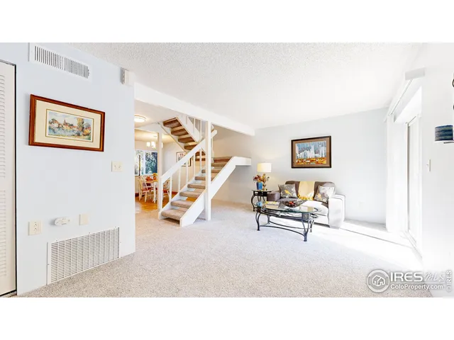 a living room with furniture and a wall painting