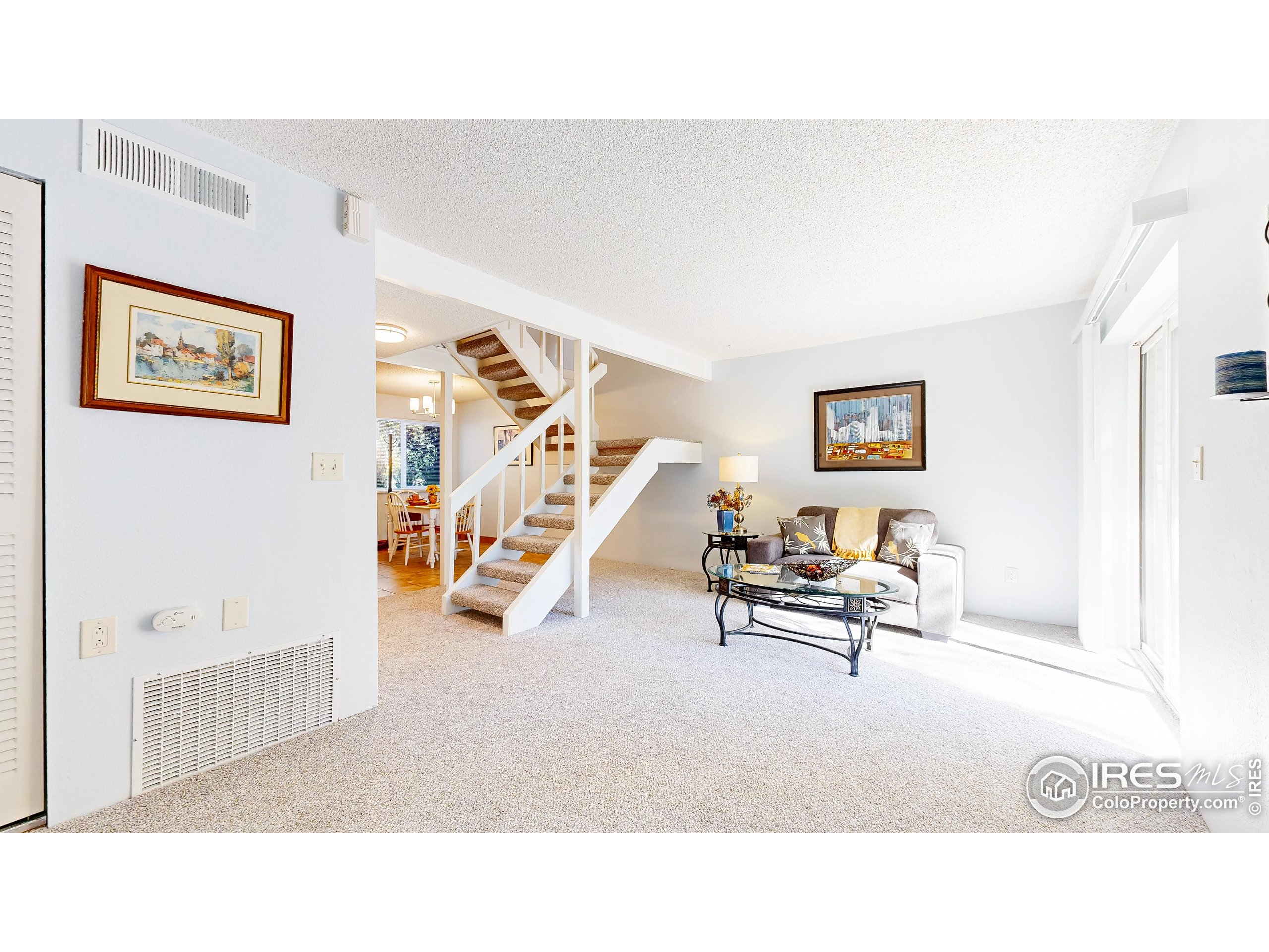 1705 Heatheridge Road, Unit K105 Fort Collins, CO 80526 - Photo 4 of 30 a living room with furniture and a wall painting