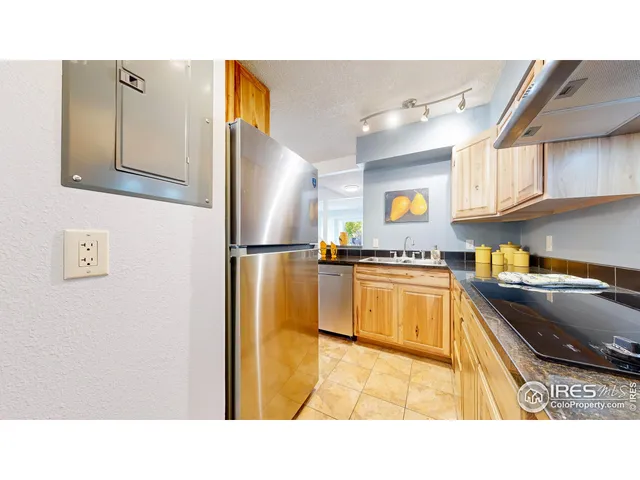 a kitchen with stainless steel appliances granite countertop a refrigerator a stove and a sink